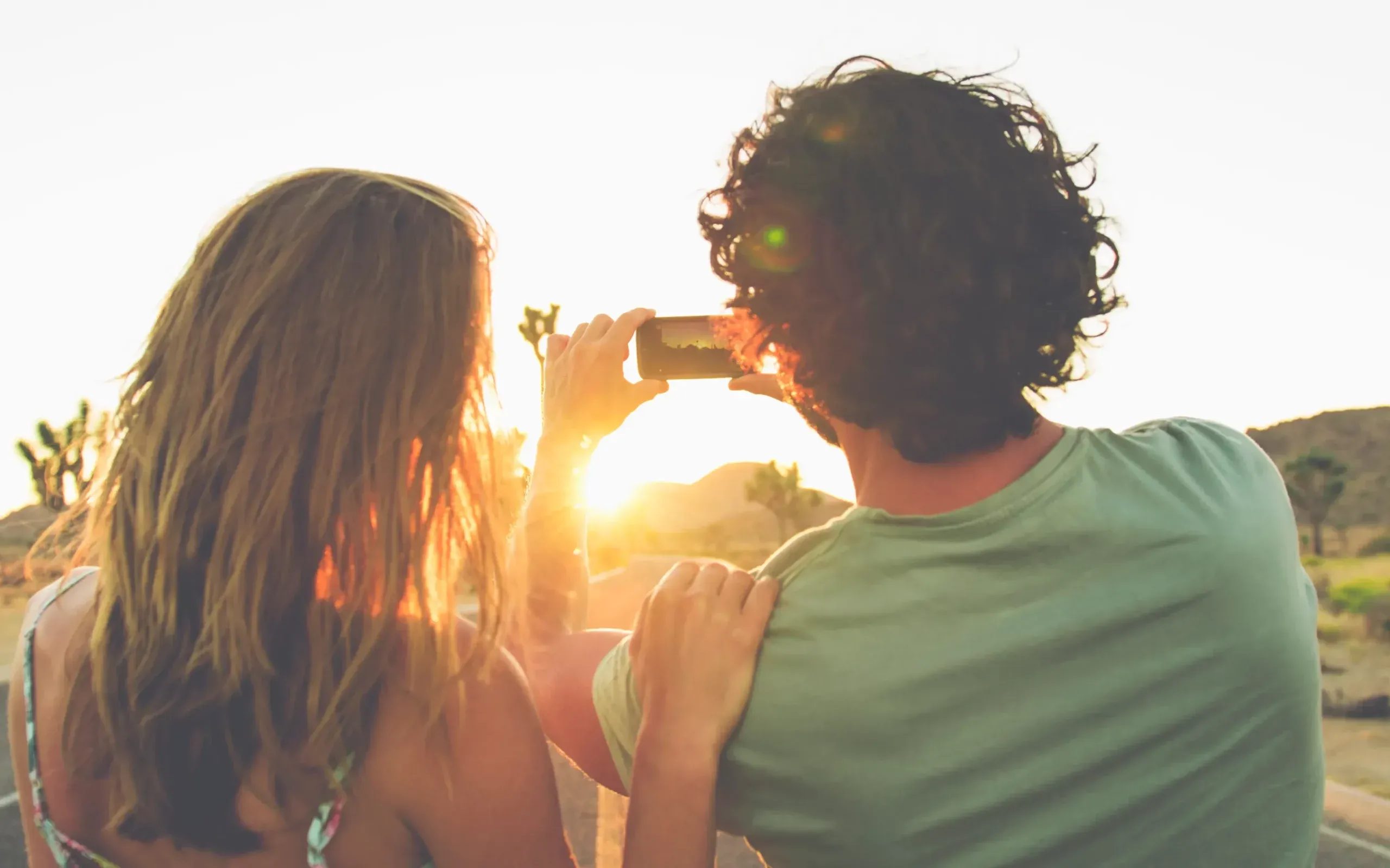 pareja haciendo fotos al atardecer